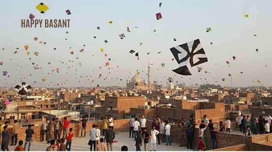 People flying colorful kites on rooftops across Lahore during Basant celebrations, with the city skyline in the background.