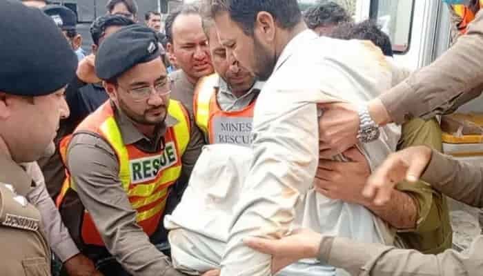 Rescue 1122 workers pull a survivor from debris after a mine collapse in Mardan