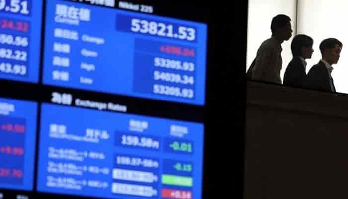 Traders watching Asia stock market screens with rising oil prices amid US Iran tensions