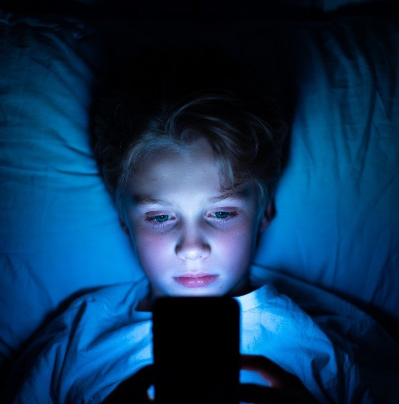 person using phone at night blue light sleep effect