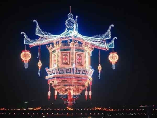 Illuminated Chinese drones forming 3D light patterns in night sky during a large synchronized drone show