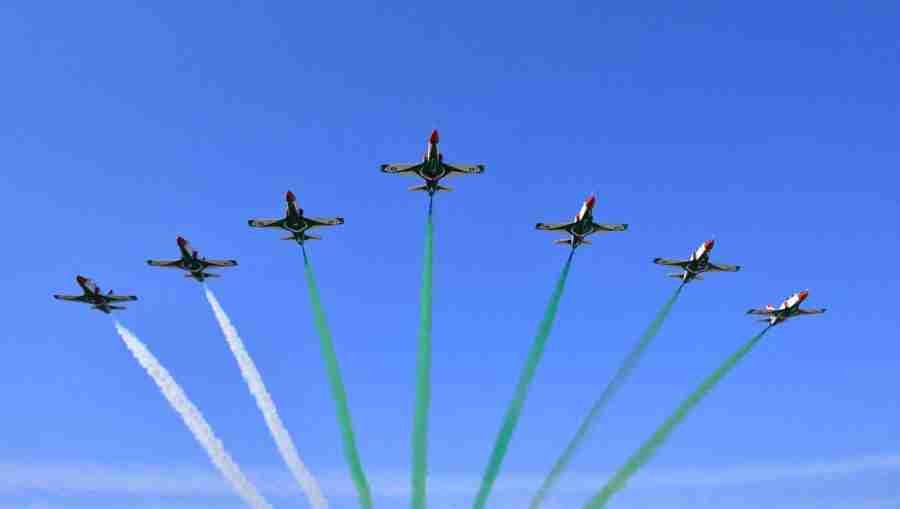 Pakistan Air Force jets flying in formation with green and white smoke trails