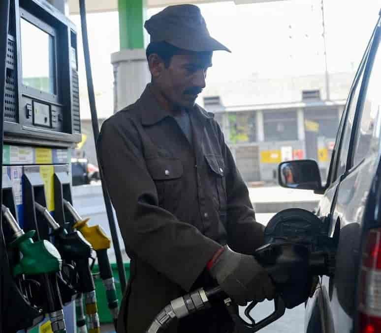 Fuel station worker filling diesel after price reduction in Pakistan