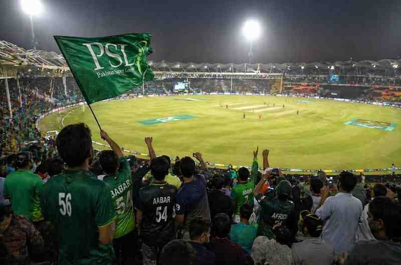 Cricket fans cheering in a packed stadium during PSL 11 playoffs match.
