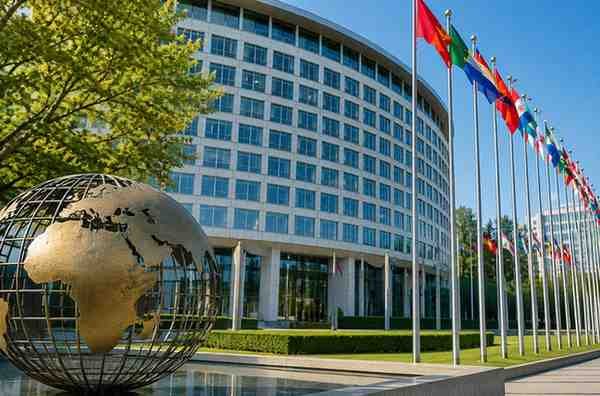 Modern international office building with global flags and globe sculpture representing UNESCO jobs and international careers