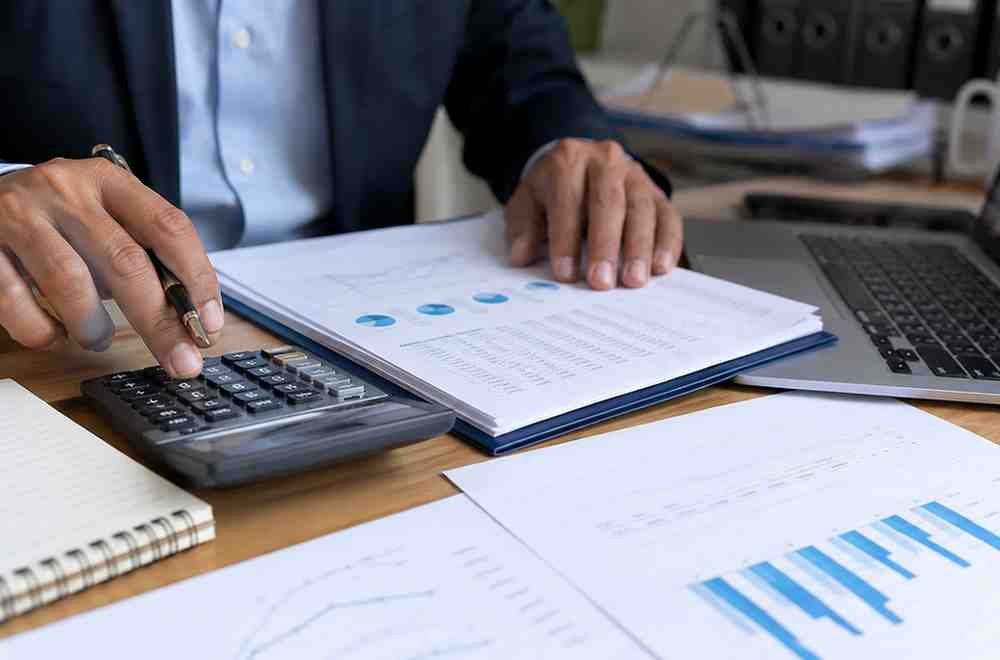 Finance Bill 2026 Approved, New Taxes Start July 1 Business professional calculating taxes with financial papers and laptop.