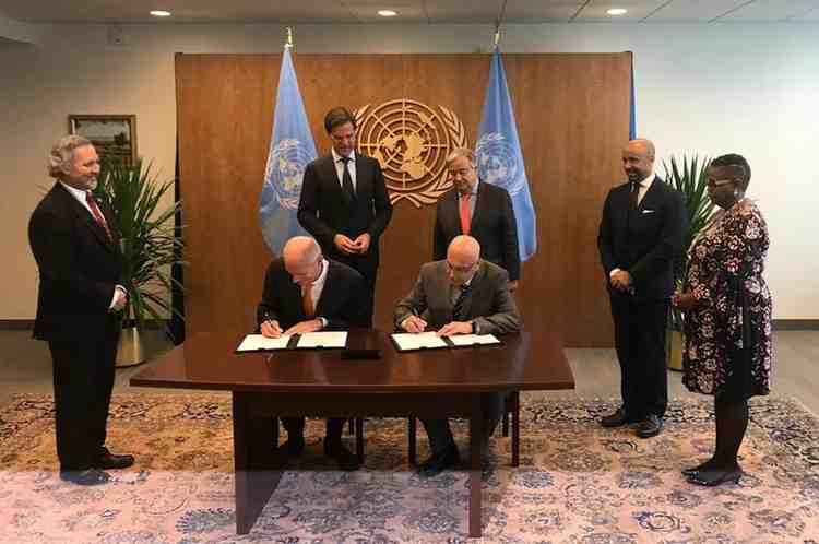 Officials witness the signing of a diplomatic agreement during an international peace ceremony.