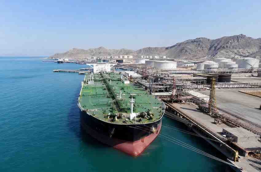 Iran Oil Imports: 3 Countries Resume Buying? Oil tanker docked at a coastal export terminal beside storage tanks and pipelines.
