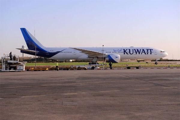 Kuwait Airways passenger aircraft parked on the runway at Kuwait International Airport.