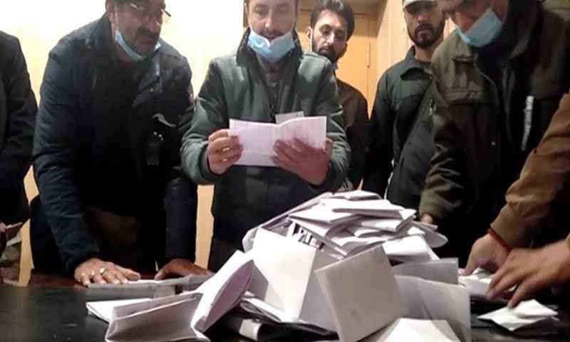 Election officials count ballot papers during the Skardu-II constituency vote tally.