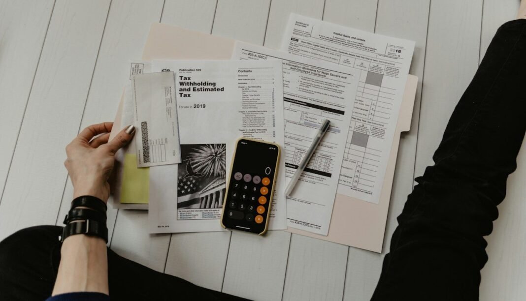 Debt Snowball vs Avalanche: Which One Actually Gets You Debt-Free Faster? Bills and a calculator on a desk, comparing debt snowball vs avalanche payoff methods