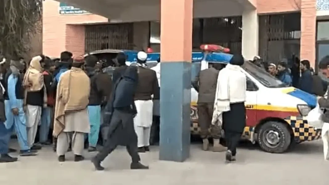 KP Police Deaths in Bannu, Lakki Marwat, Bajaur Police personnel and onlookers around a rescue vehicle after the KP police deaths