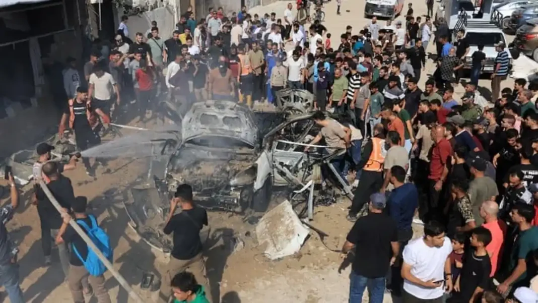 Israeli strikes and gunfire kill four in Gaza, medics say Palestinians gather around a car hit by Israeli strikes in Gaza City