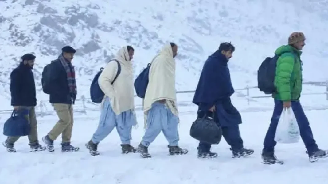 Two die as rain, snow batter Gilgit-Baltistan; Babusar Pass shut Gilgit-Baltistan rain snow: people walk through heavy snowfall as Babusar Pass closed
