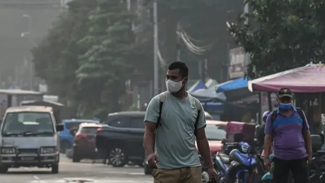 Singapore Haze: Residents Queue for N95 Masks as PSI Hits 188 in the West Singapore haze masks — man wearing face mask on a hazy street