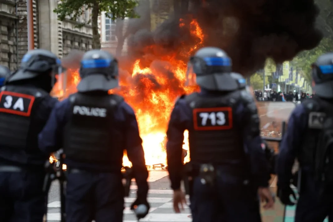 France school protests turn violent: headteacher doused in petrol, schools torched Riot police facing a burning barricade during the France school protests