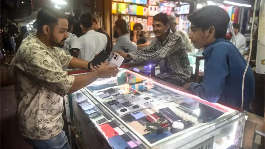 Karachi Smartphone Prices Surge Beyond Buyers’ Reach Customers at a Karachi mobile phone stall — Karachi smartphone prices