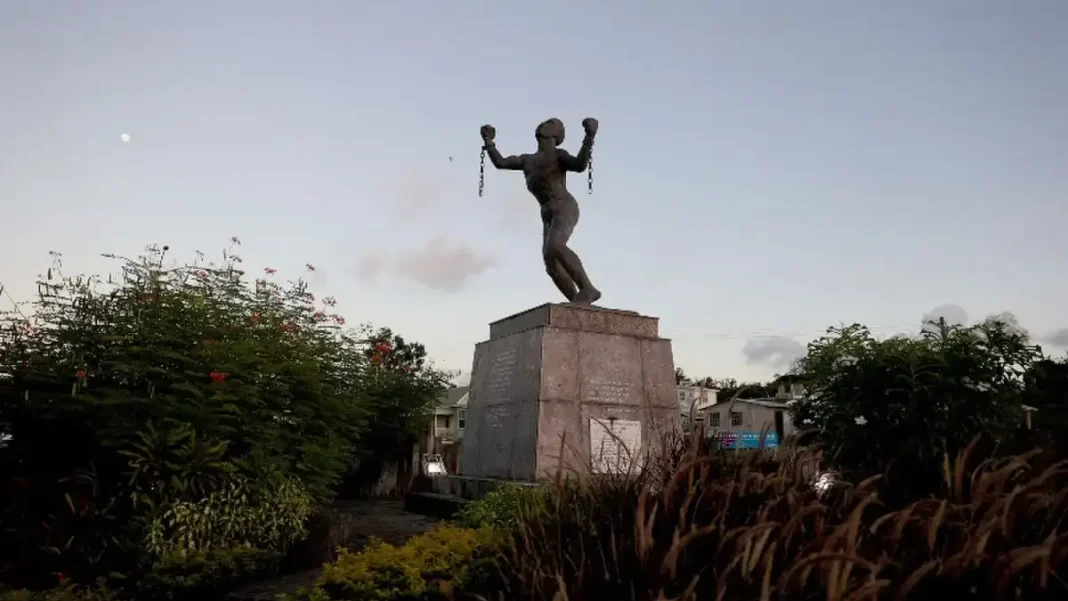 Slavery Reparations Heirs Back Caribbean Justice Call Statue of a freed slave holding broken chains — slavery reparations heirs