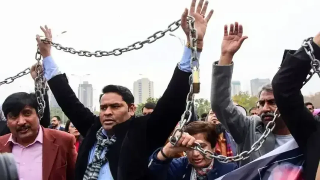 Lawfare Against Journalists Warned in New Report Protesters hold a chain during a demonstration, lawfare against journalists
