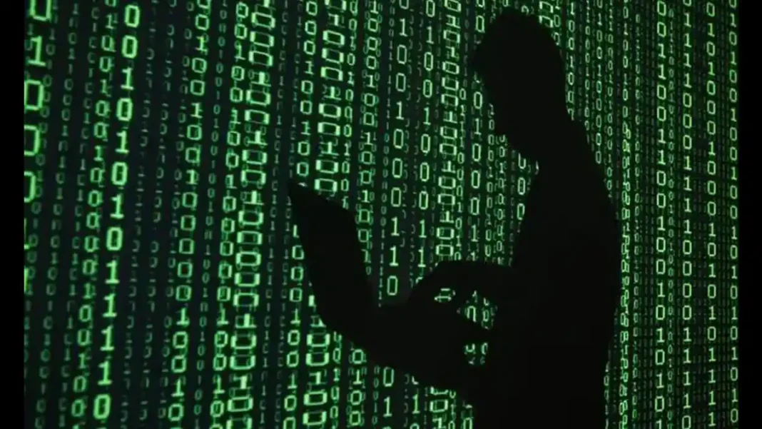 Israeli Firm Used Online Ads to Run Vast Spy Operation, Researchers Say Hooded figure with laptop against binary code; Discover-Tech spy operation ads tracked millions worldwide