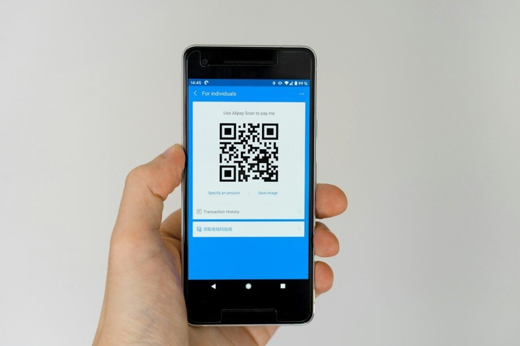 How to Scan a QR Code on Any Phone Hand holding a phone displaying a code, showing how to scan a QR code