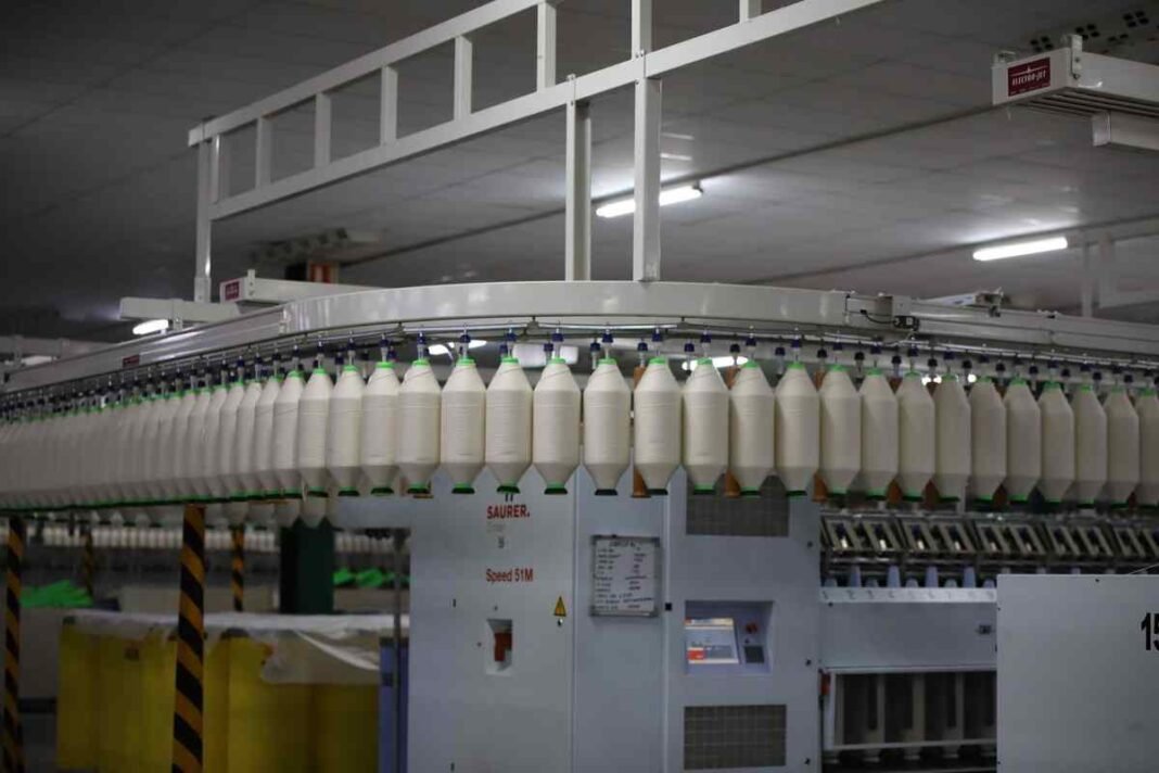 How Ibrahim Group Grew from a Faisalabad Cloth Shop into a Textile and Banking Empire Rows of yarn cones on spinning machines inside a textile mill, representing the Ibrahim Group textile business in Faisalabad