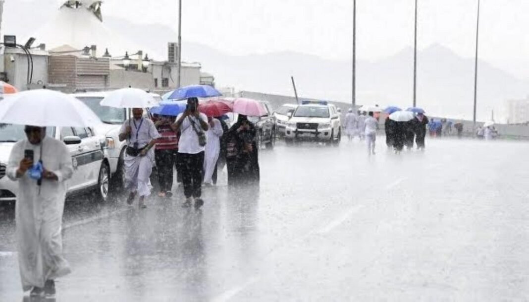 Rain in Makkah: Stunning Scenes as Showers Hit the Holy City Visitors with umbrellas in the rain in Saudi Arabia during October 2026 thunderstorms