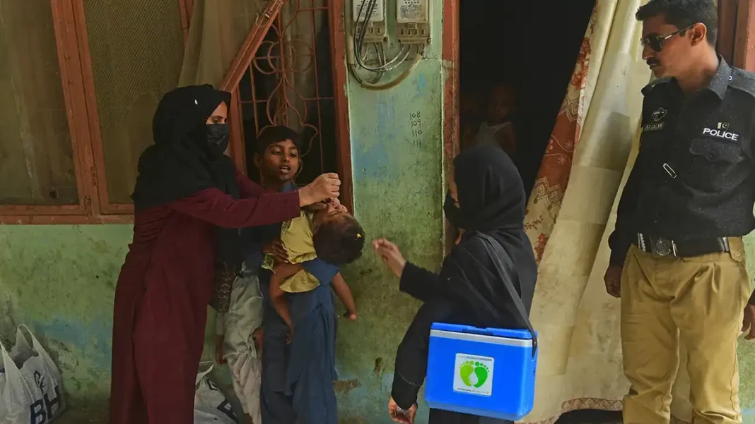 PMA Demands Security Cover as Polio Tally Reaches Seven Polio workers vaccinating a child under police guard amid Pakistan polio cases 2026