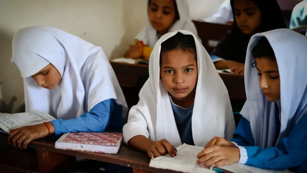 Lines About Pakistan: 10, 15 & 20 Lines for Students Young Pakistani schoolgirls in white hijabs studying at wooden desks