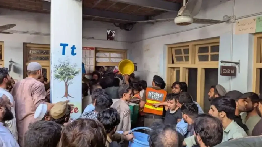 Peshawar School Roof Collapse Kills 16 Children Rescue workers and crowd at Al Khair School System in Dir Colony, Peshawar after roof collapse — Peshawar school roof collapse