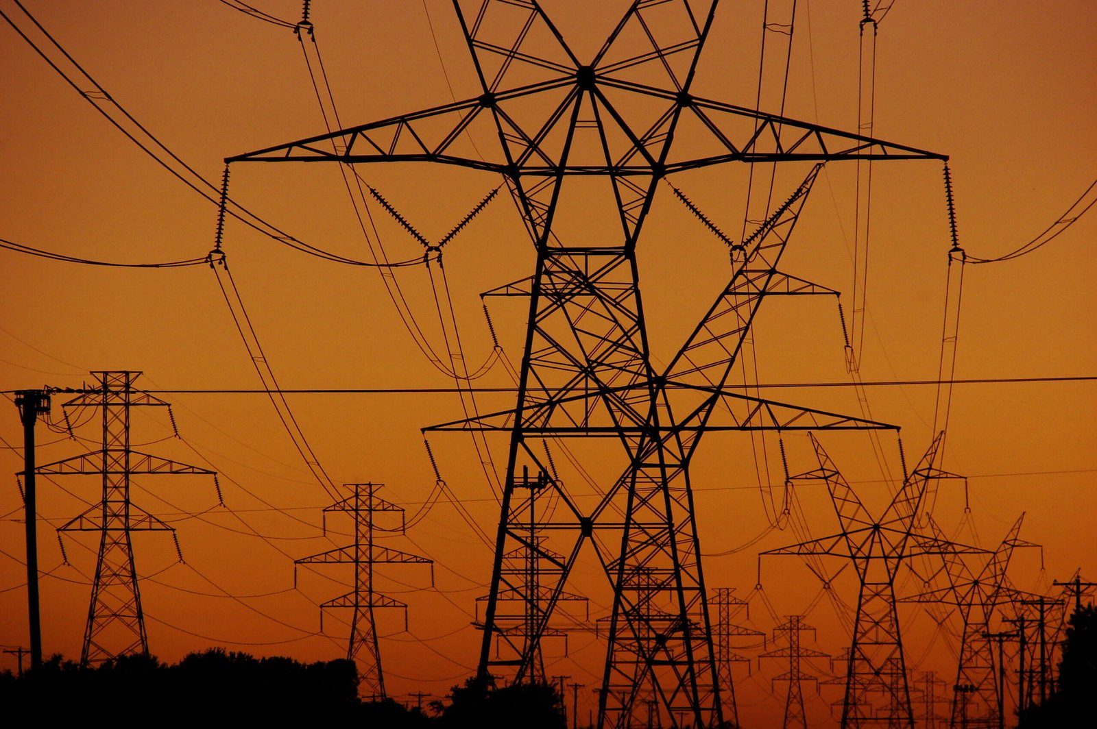 November electricity bills Pakistan — high-voltage power pylons at sunset